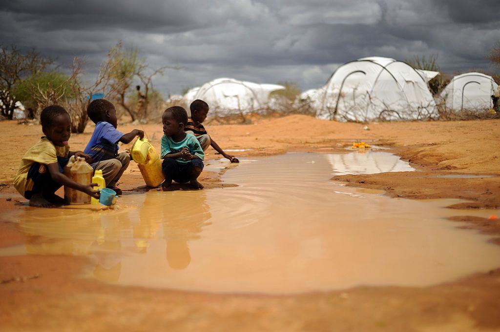 (FILES) This file photo taken on October 16, 2011 shows Somali boys fetching water from a puddle that formed after rain at the IFO-2 complex of the sprawling Dadaab refugee complex in Kenya.  AFP / Tony KARUMBA
