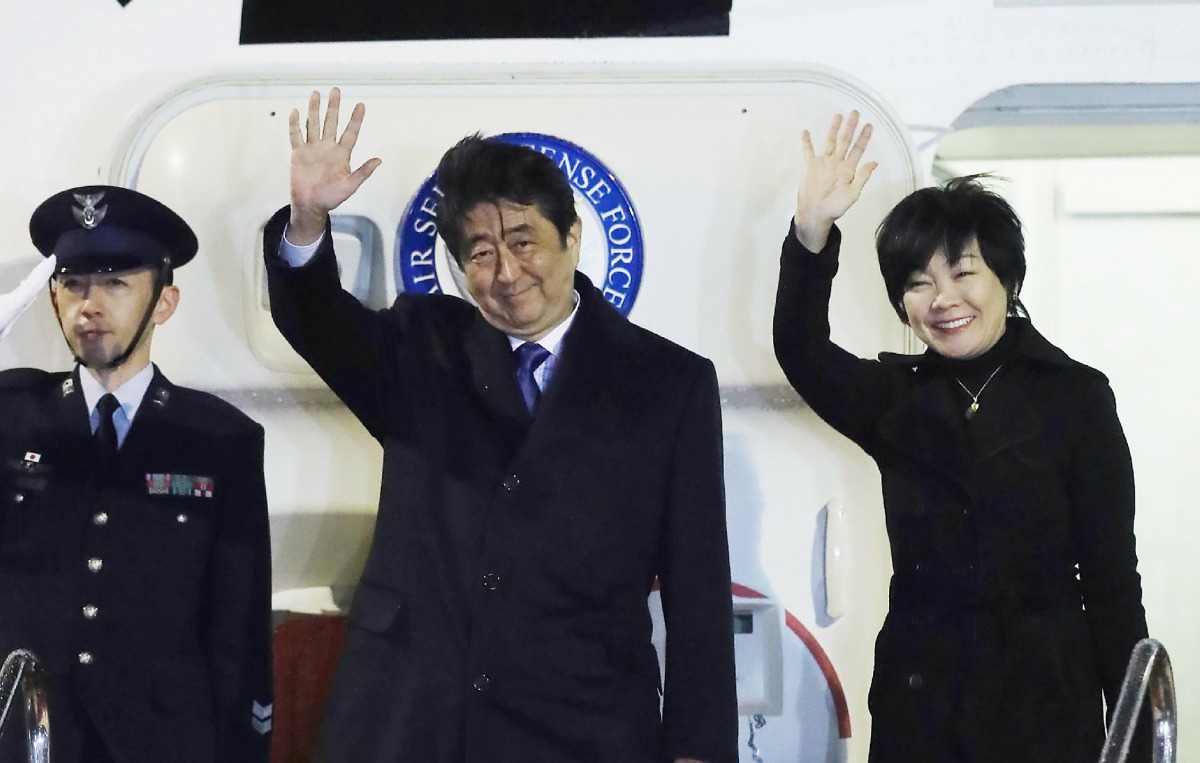 Japan's Prime Minister Shinzo Abe (C) and his wife Akie (R) wave to people seeing them off from the government plane before leaving Haneda Airpot in Tokyo for Washington DC on February 9, 2017. AFP / JIJI PRESS / STR
