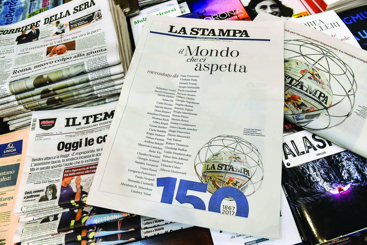 A photo taken on February 9, 2017 shows a copy of the 150th anniversary edition of Italian newspaper La Stampa at a newsstand in central Rome. Several dozen world personalities, from Pope Francis to Donald Trump and Roger Federer, wrote a message publishe