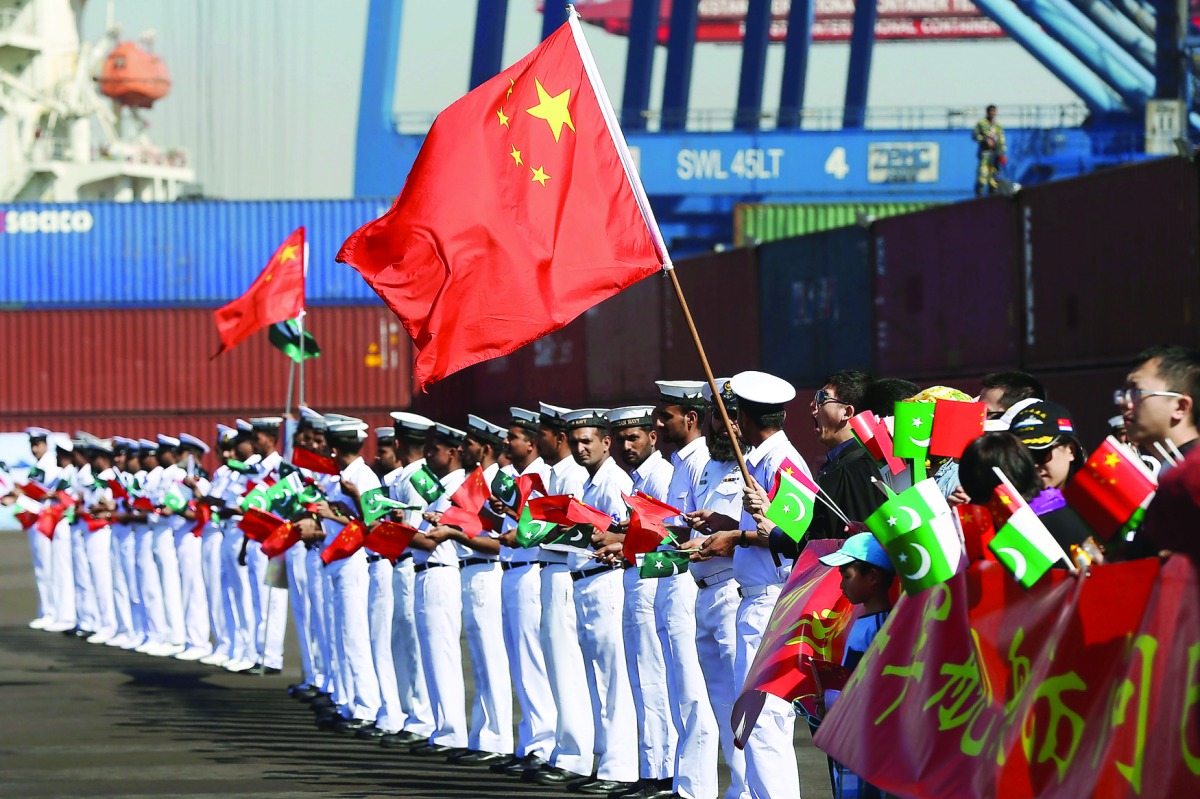 Chinese families along with Pakistan Navy's servicemen wave flags to welcome a Chinese naval vessel (unseen) upon its arrival to participate in Pakistan Navy’s Multinational Exercise AMAN-17, in Karachi, Pakistan, February 9, 2017. REUTERS/Akhtar Soomro