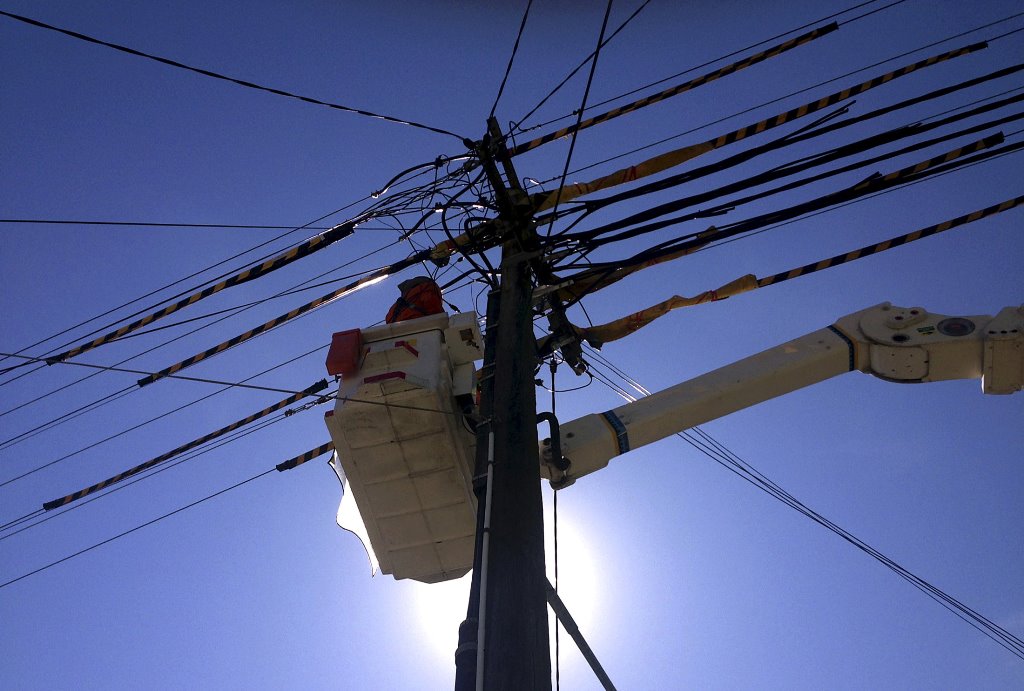 FILE PHOTO - A worker stands in a crane as he fixes electricity cables attached to a pole on a suburban street in Sydney, Australia, November 10, 2015. Reuters/David Gray/File Photo
