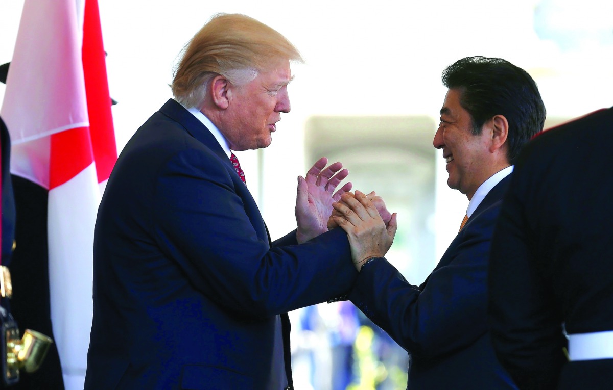 Japanese Prime Minister Shinzo Abe is greeted by US President Donald Trump ahead of their meeting and joint news conference at the White House, in Washington, yesterday.