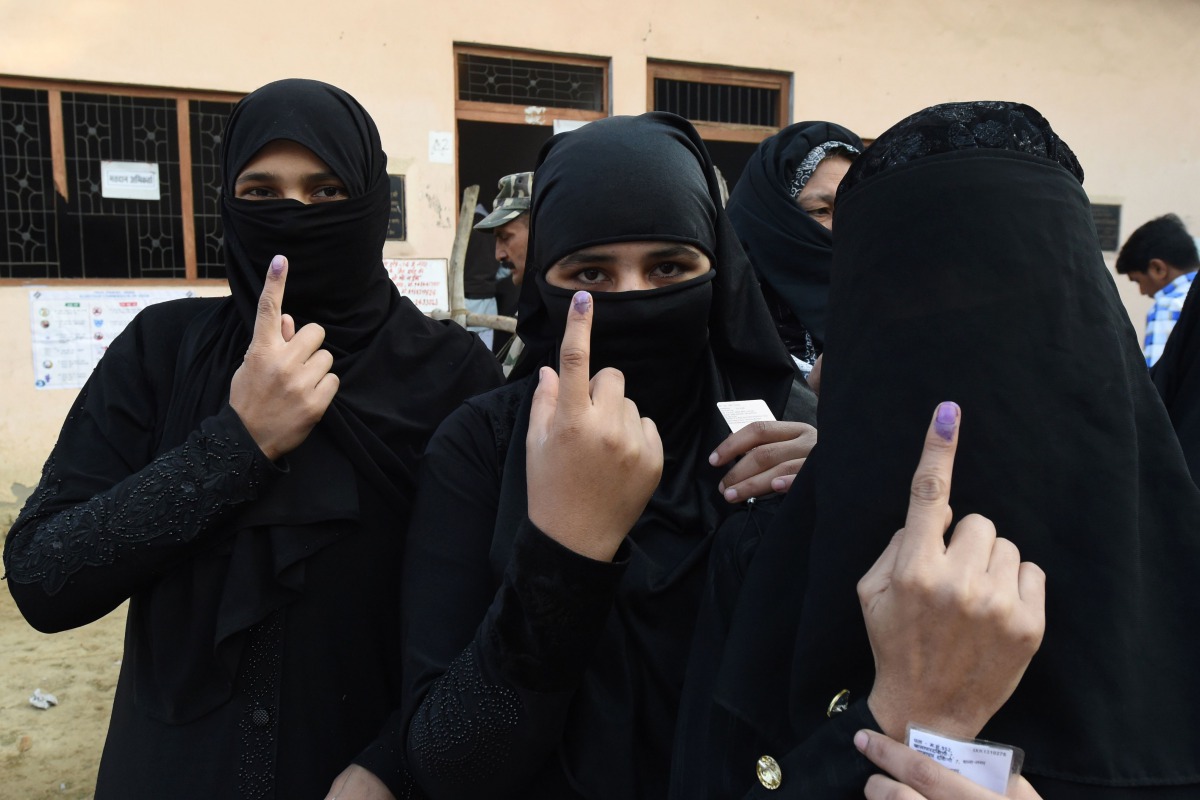 Muslim women show their fingers, which were marked after they cast their votes, at a polling station in Muzaffarnagar in Uttar Pradesh on February 11, 2017. AFP / Prakash SINGH