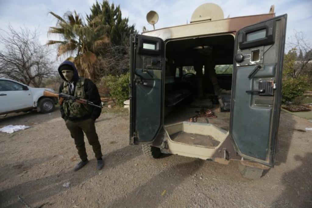 A rebel fighter stands with his weapon near a military vehicle on the outskirts of the northern Syrian town of al-Bab, Syria February 8, 2017. REUTERS/Khalil Ashawi.