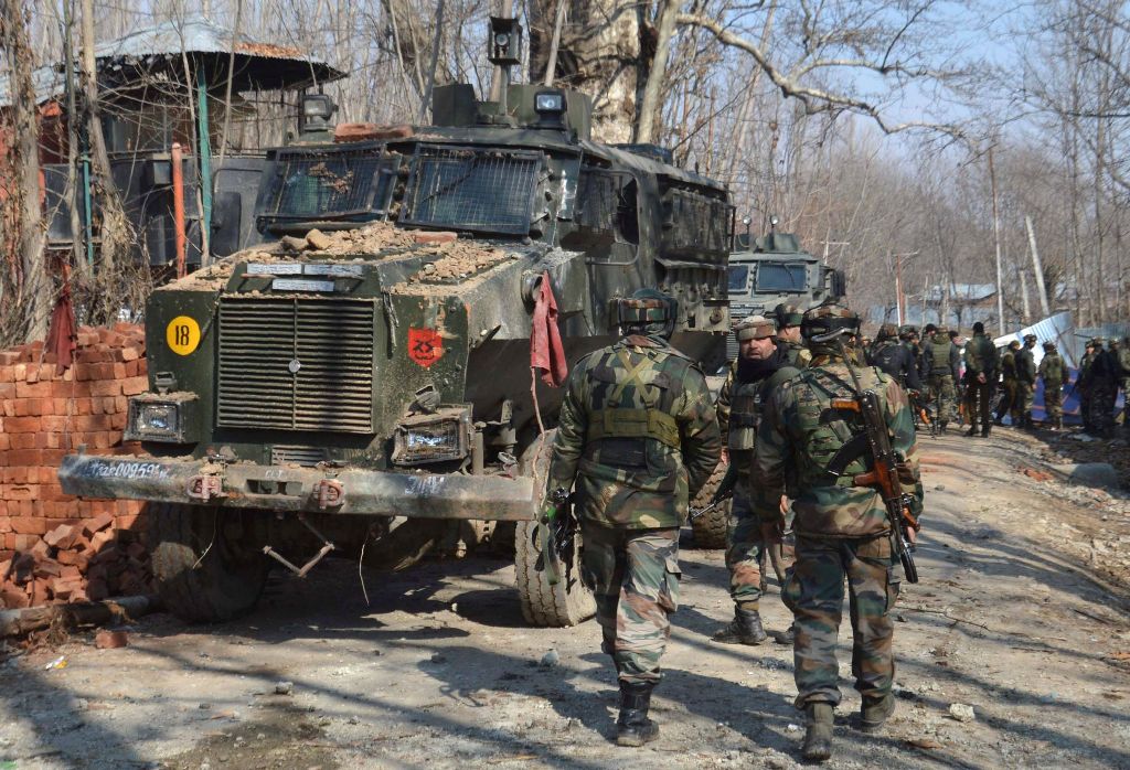 Indian security personnel walk through the scene of a firefight in Frisal village in Kulgam, some 70 kms south of Srinagar, on February 12, 2017. AFP