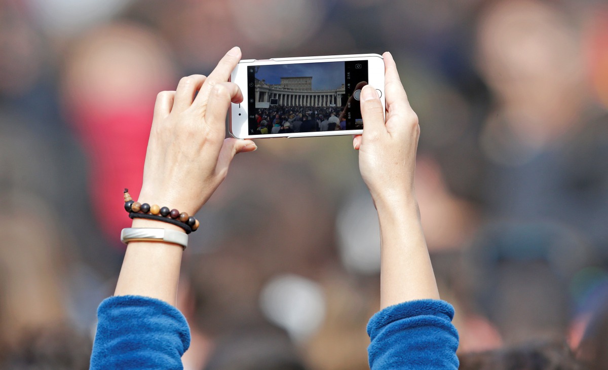 A faithful takes a picture as Pope Francis leads the weekly Angelus prayer in Saint Peter's Square at the Vatican, February 12, 2017. REUTERS/Max Rossi