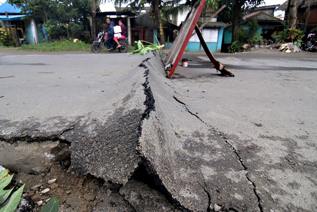 A motorcyclist rides around an asphalt road, which was damaged after a 6.5-magnitude earthquake struck overnight, in Surigao City in southern island of Mindanao on February 11, 2017. Rescuers dug through rubble on February 11 to find survivors after a pow