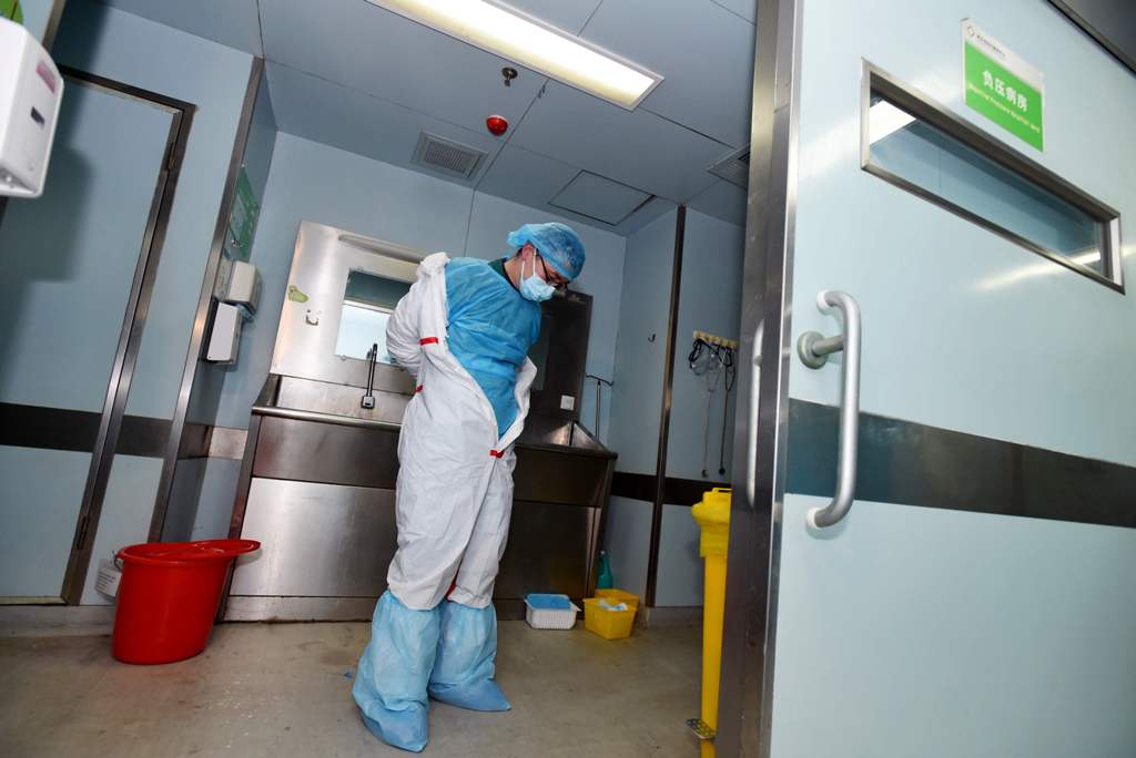 This photo taken on February 12, 2017 shows a member of staff taking off his decontamination suit after treating a H7N9 bird flu patient in a hospital in Wuhan, central China's Hubei province. / AFP / STR
