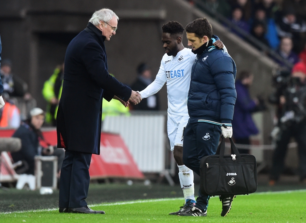 Swansea City's Nathan Dyer receives medical attention after sustaining an injury while Leicester City manager Claudio Ranieri looks on. Reuters / Rebecca Naden 
