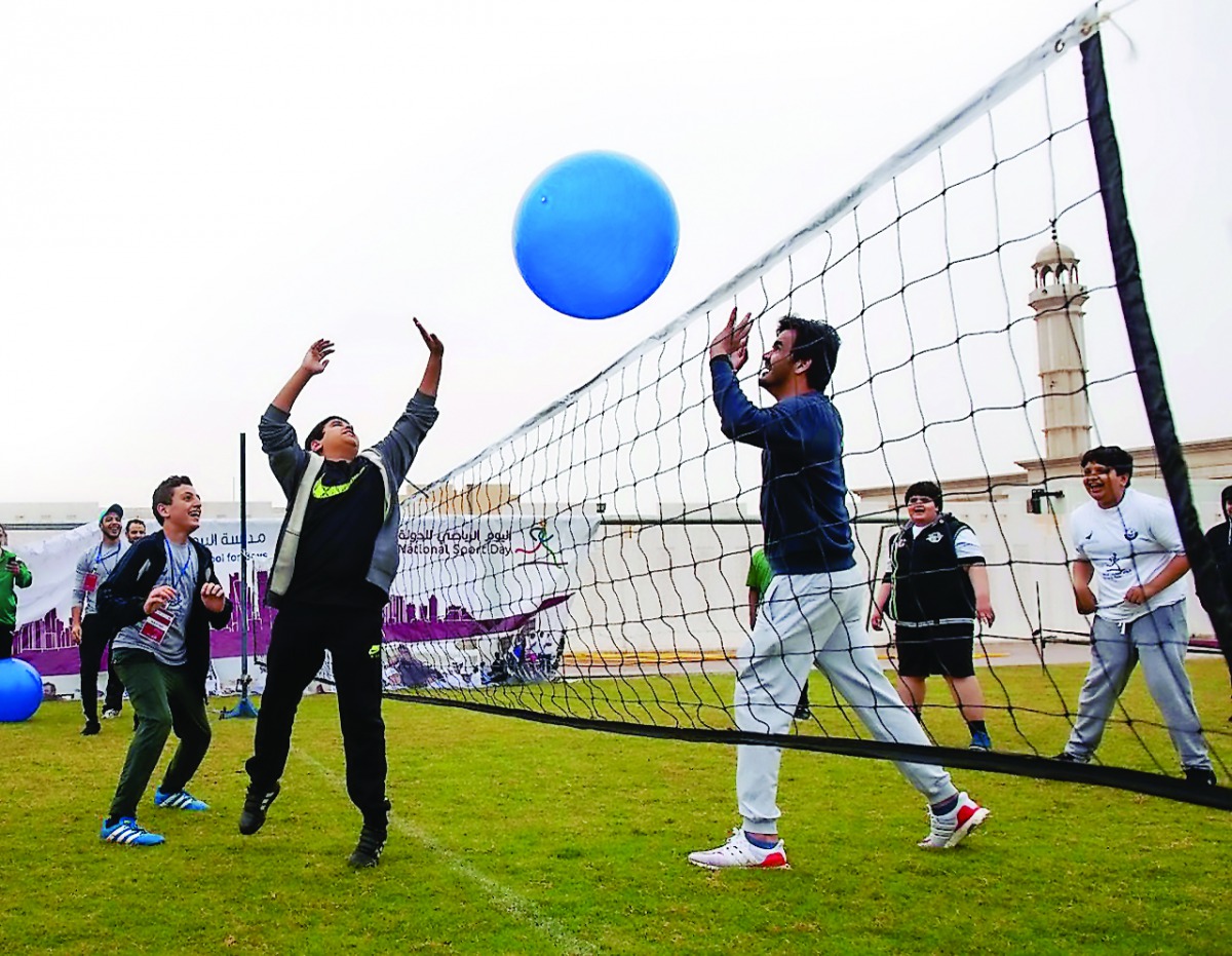 President of the Qatar Olympic Committee, H E Sheikh Joaan bin Hamad Al Thani plays with kids during the National Sport Day celebrations in Doha yesterday.