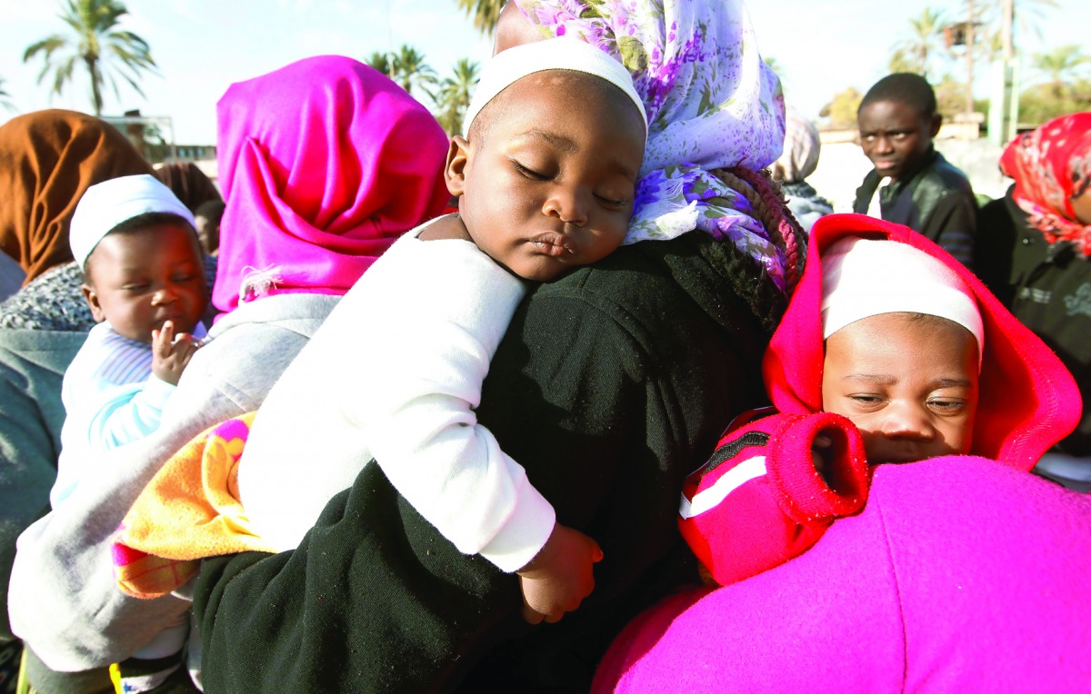 African migrants carry their children as they wait to be deported at Mitiga International Airport, east of Tripoli, yesterday.