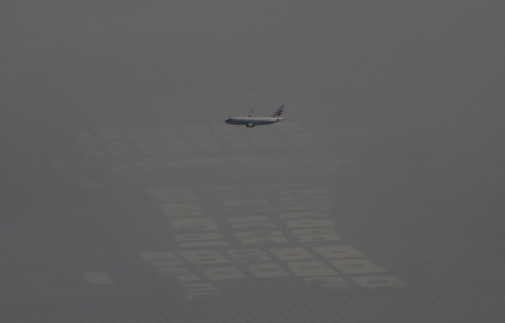 FILE PHOTO: An Air China passenger aircraft flies amid heavy smog over the suburb of Beijing, China, January 2, 2017. REUTERS/Jason Lee/File Photo
