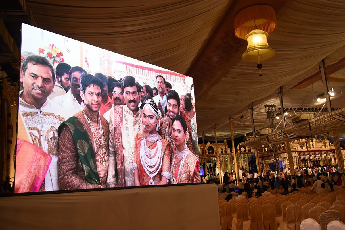 Indian mining tycoon, Gali Janardhan Reddy, (C) on a big screen as he poses with his daughter Bramhani (2R) and son-in-law, Rajeev Reddy (2L) during their wedding at the Bangalore Palace Grounds in Bangalore on November 16, 2016 AFP