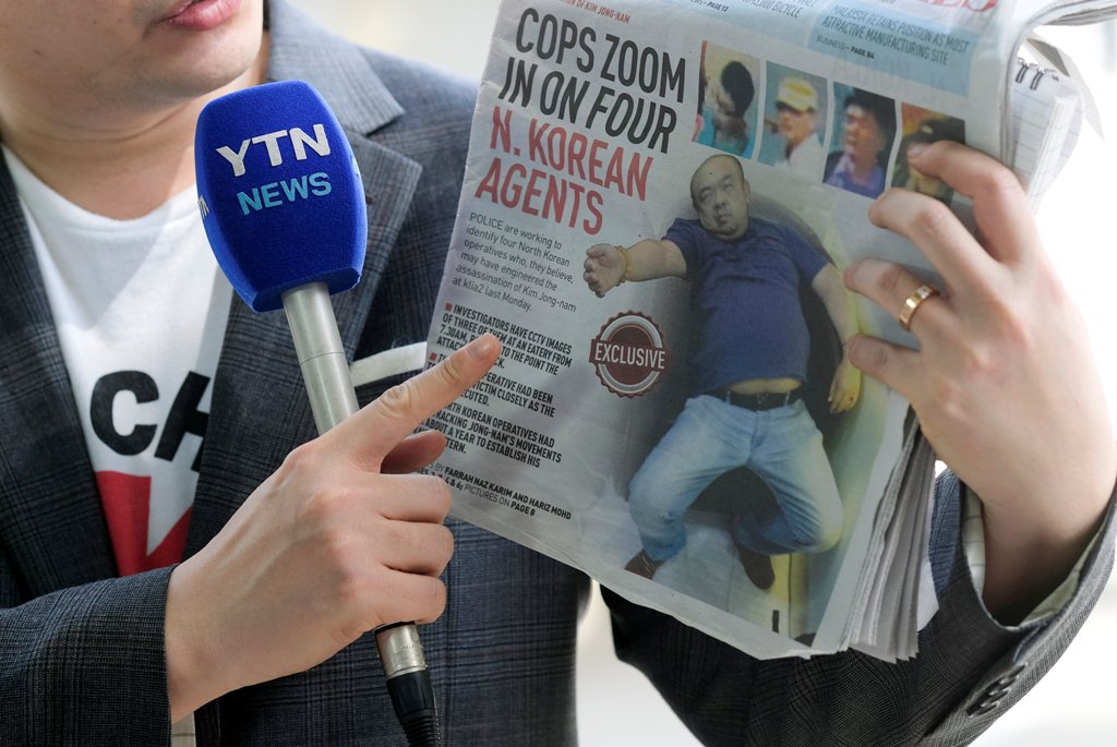A reporter holds up a local newspaper during his report in front of the morgue at Kuala Lumpur General Hospital where Kim Jong Nam's body is held for autopsy in Malaysia February 18, 2017. REUTERS/Athit Perawongmetha