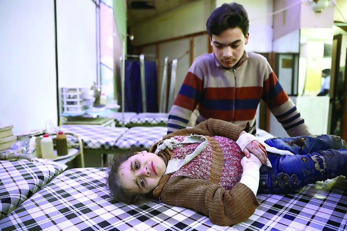 A wounded Syrian girl cries as she waits to receive treatment at a make-shift hospital following an airstrike on the rebel-held town of Douma, yesterday.