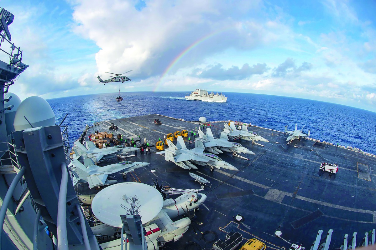 The aircraft carrier USS Carl Vinson participating in a replenishment-at-sea with the Black Knights of Helicopter Sea Combat Squadron 4 and the cargo and ammunition ship USNS Charles Drew (rear). The Vinson aircraft carrier strike group is patrolling the 