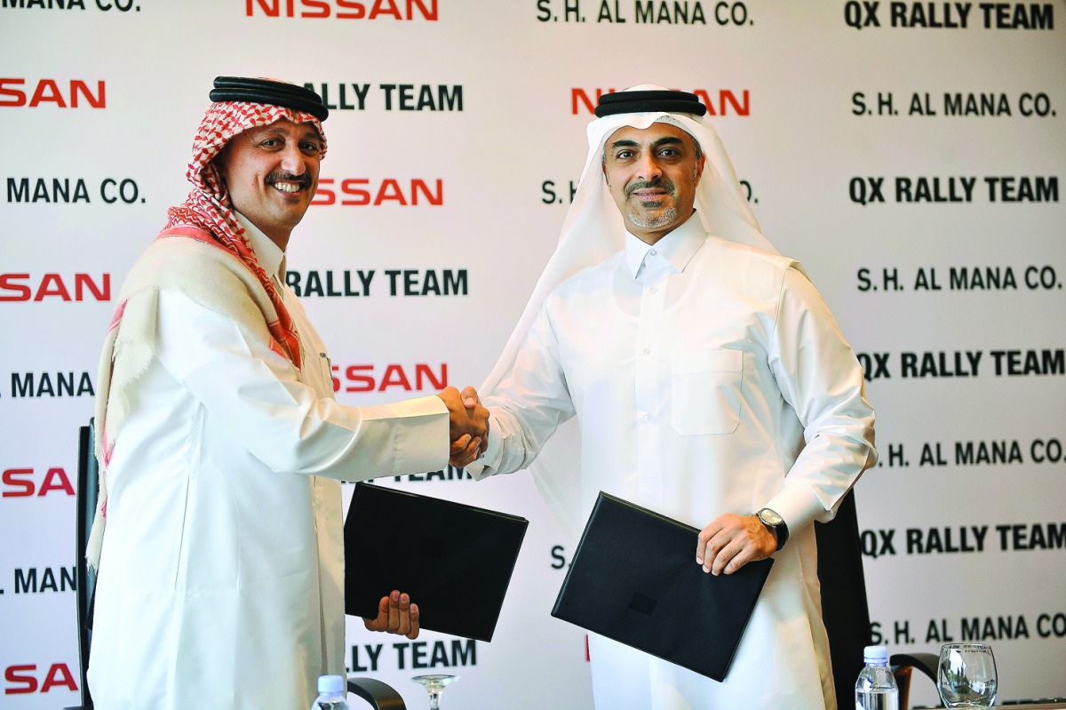 Adel Hussein, the world rally champion and Hisham Saleh Al Mana, Chairman and Managing Director of Nissan shake hands after renewing the deal between Nissan and QX Rally Team at the main Nissan showroom in Doha.Picture: Baher Amin/The Peninsula