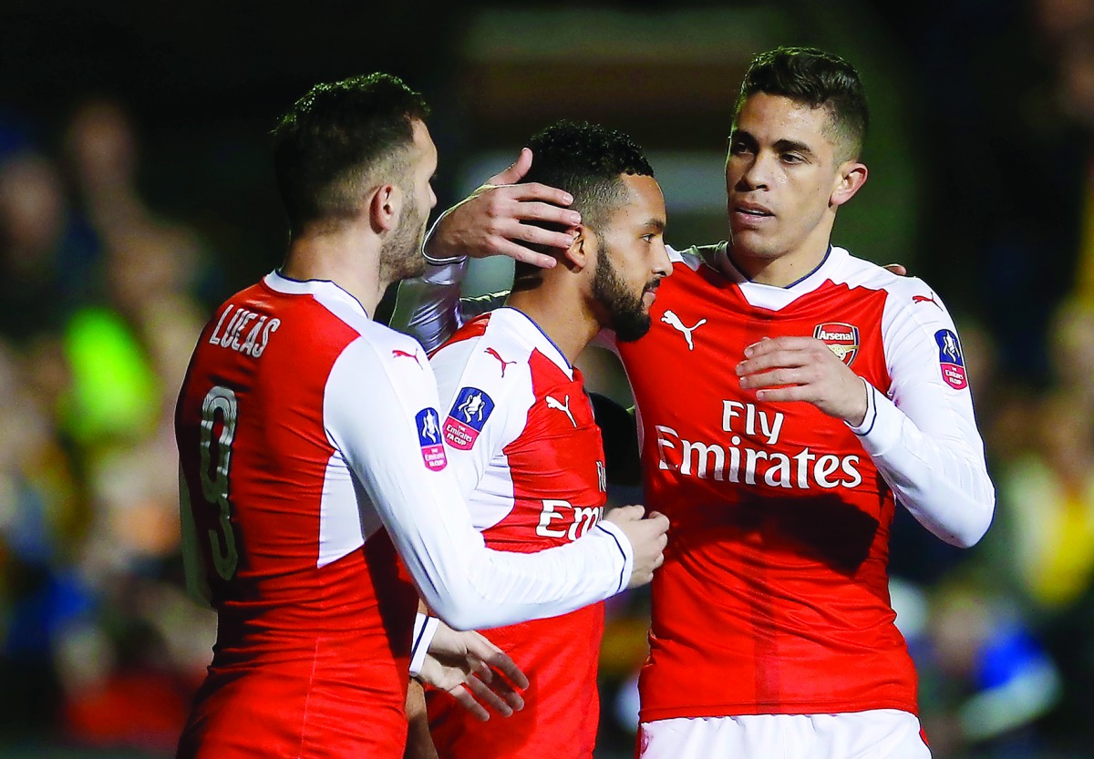 Arsenal's Theo Walcott (centre) celebrates with team-mates Lucas Perez and Gabriel Paulista after scoring their second goal against non-league minnows Sutton United in the FA Cup on Monday.