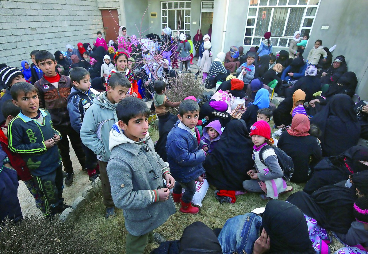 Iraqi families who fled the front line gather in the village of Al Buseif, south of Mosul, during an offensive by Iraqi forces to retake the western side of the city from Islamic State (IS) group fighters, yesterday.