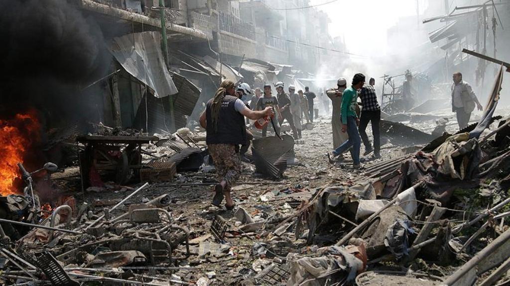 People walking through wreckage of buildings and damaged stores are seen after warcrafts belonging to Syrian army bombed a bazaar in Maarrat al-Nu'man, south of Idlib, Syria on April 19, 2016.