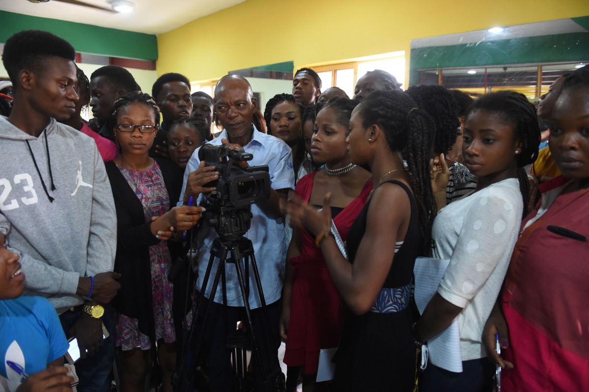A teacher (C) at the PEFTI Film Institute teaches students to use a video camera at the school in Lagos on February 2, 2017. Nollywood film 