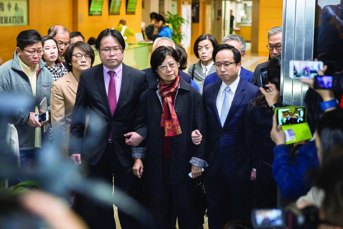 Selina Tsang (centre), wife of former Hong Kong Chief Executive Donald Tsang, is accompanied by her two sons, Simon Tsang Hing-yin (centre left) and Thomas Tsang Hing-shun (centre right), as they leave the High Court, in Hong Kong, yesterday.