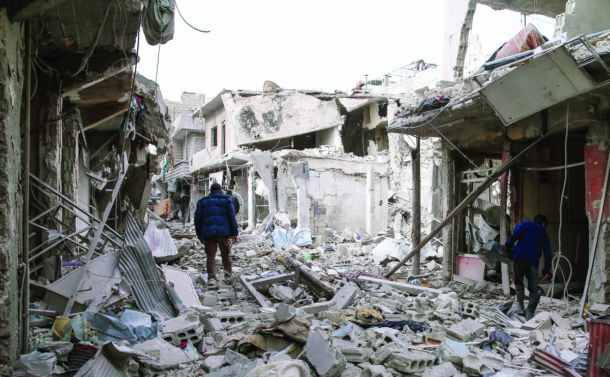 Syrian civil defence volunteers, known as the White Helmets, search for survivors following a government air strike on the rebel-held neighbourhood of Tishrin, on the northeastern outskirts of Damascus, yesterday.
