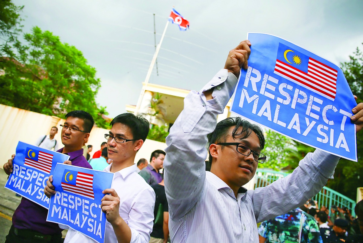 Members of the youth wing of the National Front, hold placards during a protest at the North Korea embassy in Kuala Lumpur, yesterday.