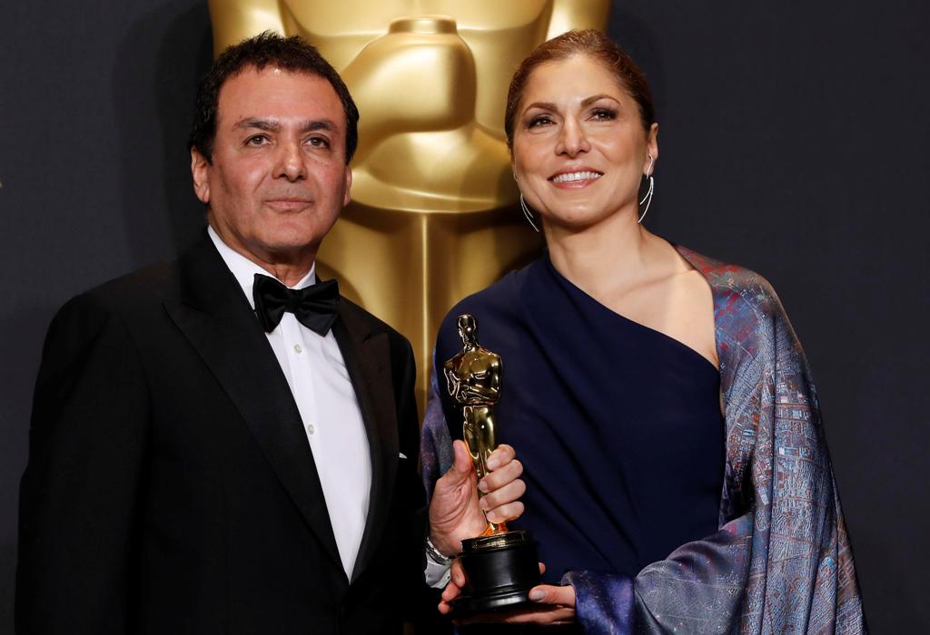 Anousheh Ansari and Firouz Naderi pose with the Oscar they accepted on behalf of Asghar Farhadi, who won the Best Foreign Language Film for 
