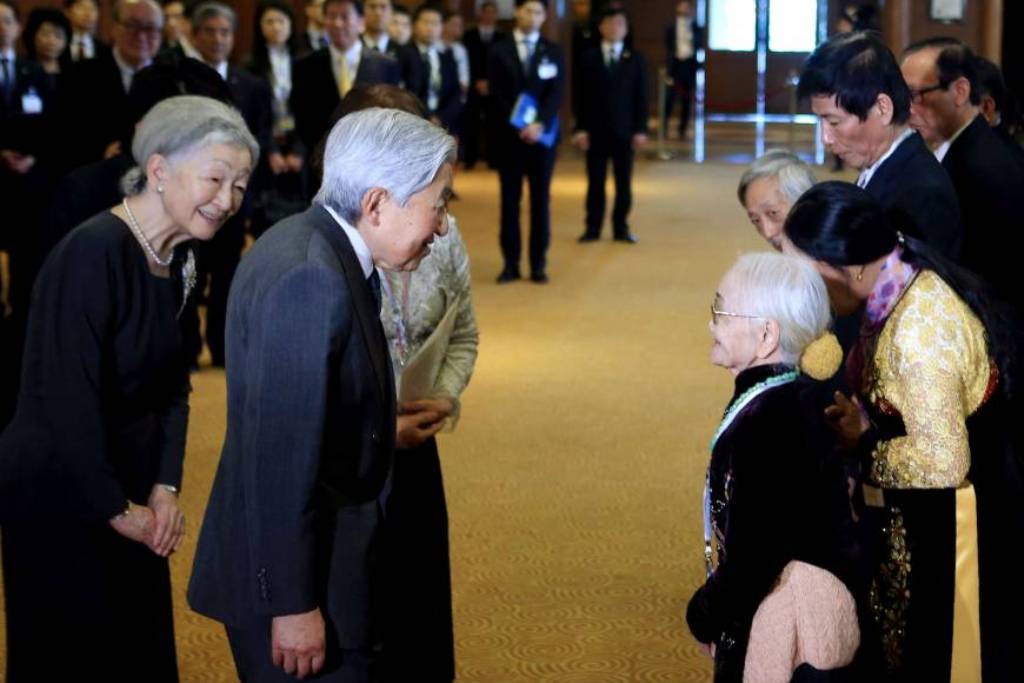 Nguyen Thi Xuan (right), 92, who married a former Japanese soldier, greets Japan's Emperor Akihito and Empress Michiko as they meet at a hotel in Hanoi with family members of Japanese veterans living in Vietnam on Thursday. | AFP-JIJI.