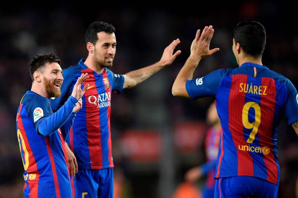 Barcelona's Argentinian forward Lionel Messi (L) celebrates with Barcelona's midfielder Sergio Busquets (C) and Barcelona's Uruguayan forward Luis Suarez after scoring during the Spanish league football match FC Barcelona vs Real Sporting de Gijon at the 