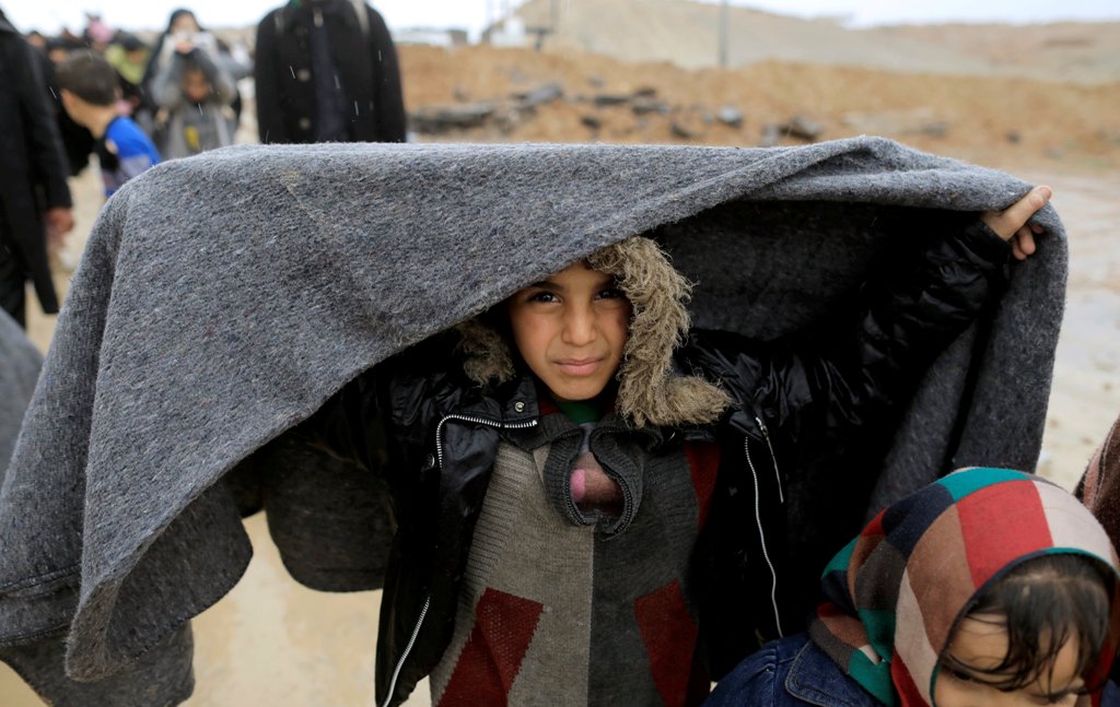 Displaced Iraqis walk under rain while fleeing their homes, as Iraqi forces battle with Islamic State militants in western Mosul, Iraq, March 4, 2017. REUTERS/Zohra Bensemra
