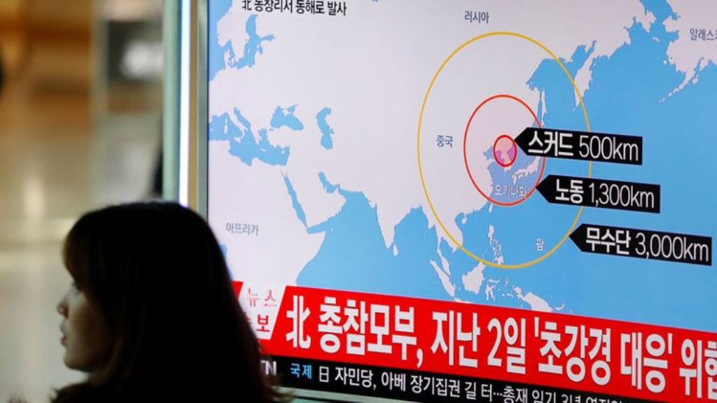 A woman walks past a television broadcasting a news report on North Korea firing ballistic missiles, at a railway station in Seoul on Mar 6, 2017. (Photo: Reuters).