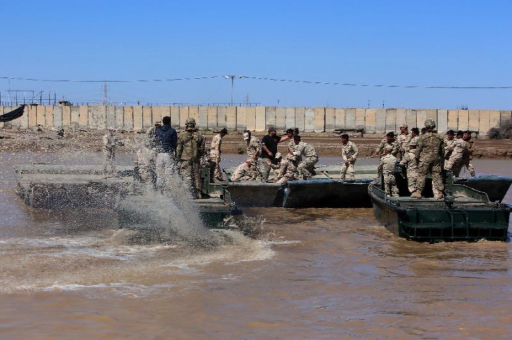 International coalition forces and Iraqi soldiers instal a floating bridge at the Taji camp, north of Baghdad, during a training session ahead of installing replacement bridges in Mosul, on March 6, 2017 (AFP Photo/Sabah Arar).