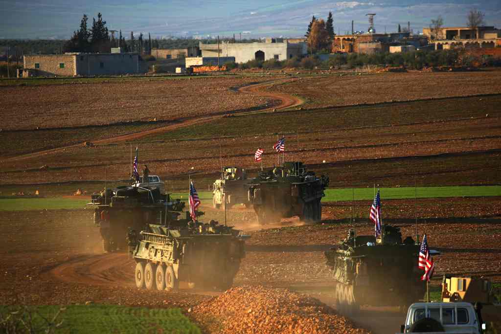 (FILES) This file photo taken on March 5, 2017 shows a convoy of US forces armoured vehicles driving near the village of Yalanli, on the western outskirts of the northern Syrian city of Manbij.  AFP / DELIL SOULEIMAN

