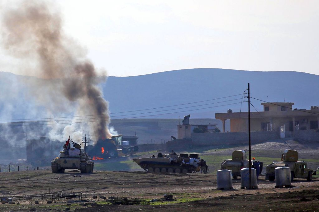 Iraqi government forces supported by fighters from the Abbas Brigade, which fight under the umbrella of the Shiite popular mobilisation units, advance in village of Badush some 15 kilometres northwest of Mosul during the ongoing battle to retake the city'