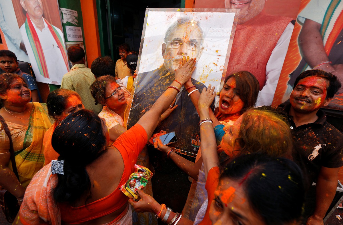 Supporters of the Bharatiya Janata Party (BJP) celebrate after learning of the initial poll results outside the party headquarters in Kolkata, India, March 11, 2017. (REUTERS/Rupak De Chowdhuri)