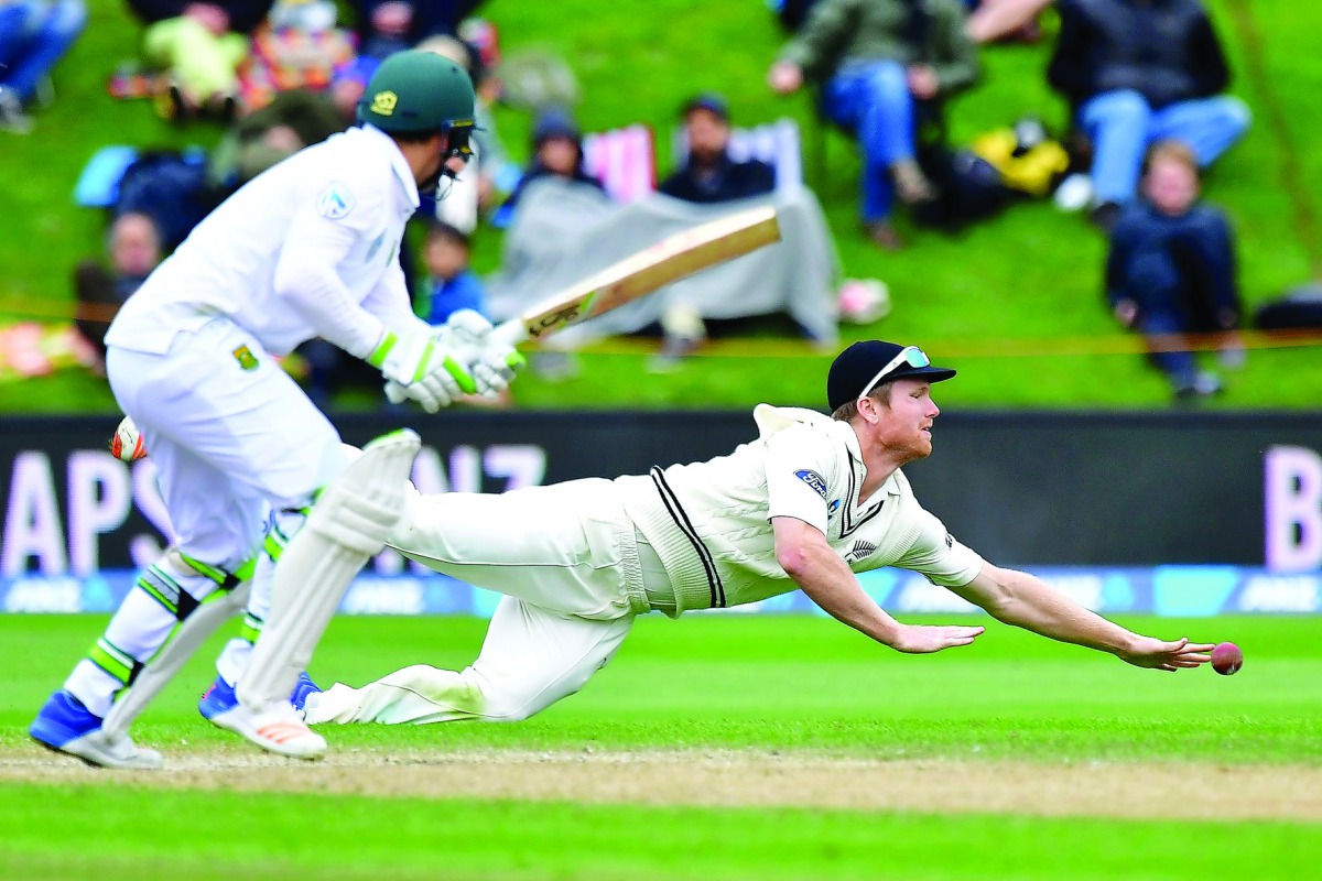 New Zealand's James Neesham (right) attempts to catch South Africa's Dean Elgar during day four of their first Test in Dunedin yesterday. 