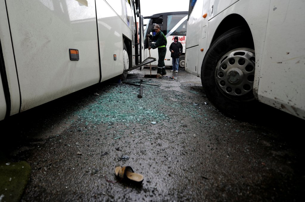 A worker clears shattered glass at the site of an attack by two suicide bombers in Damascus, Syria March 11, 2017. REUTERS/Omar Sanadiki.