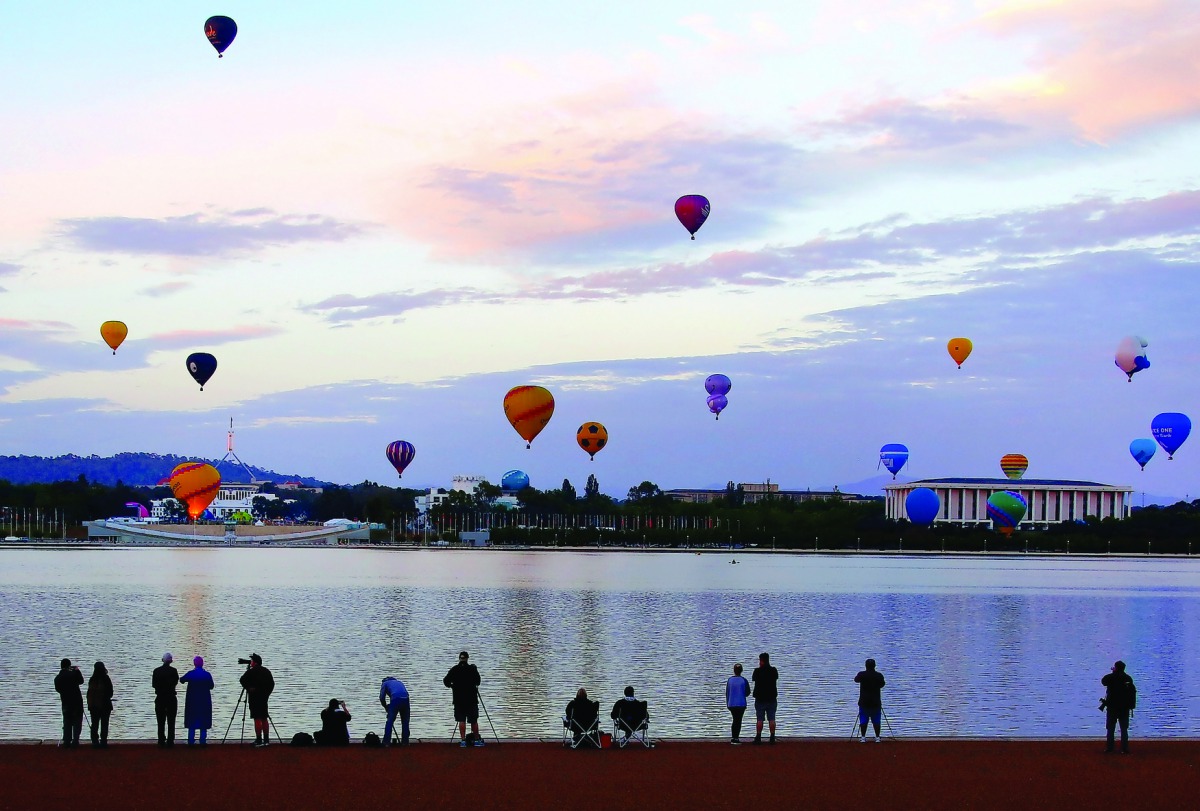Members of the public watch as balloons participating in the Canberra Balloon Festival fly above the Australian capital city, March 12, 2017. REUTERS/David Gray