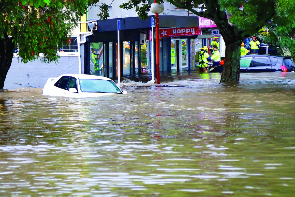 Rescue workers assist stranded people from floodwaters in the Auckland suburb of New Lynn in New Zealand