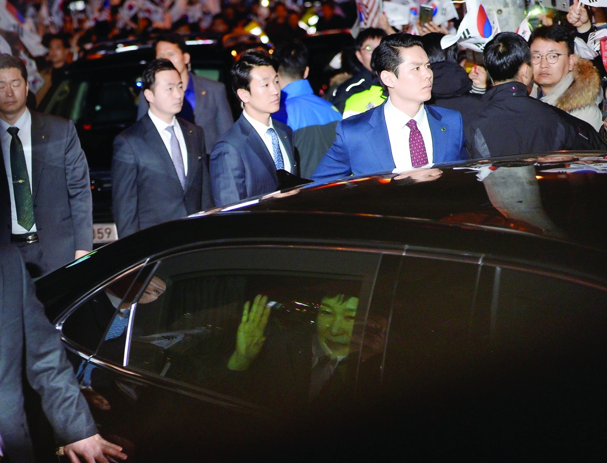 South Korea's ousted leader Park Geun-hye sitting inside a car waves to her supporters upon her arrival to her private house in Seoul, yesterday.