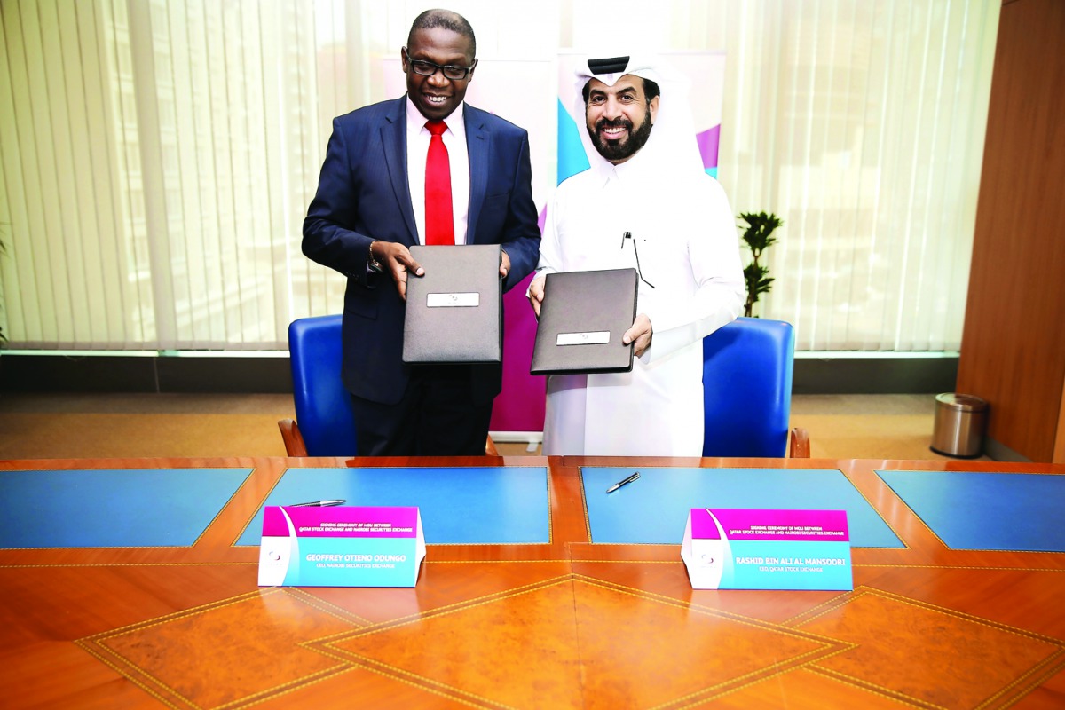 Rashid bin Ali Al-Mansoori, CEO of Qatar Stock Exchange (right) and  Geoffrey Otieno Odungo, CEO of Nairobi Securities Exchange exchanging documents in Doha.
