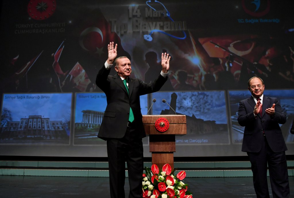 Turkish President Tayyip Erdogan, accompanied by Health Minister Recep Akdag, greets the audience during a meeting in Ankara, Turkey, March 14, 2017. Murat Cetinmuhurdar/Presidential Palace