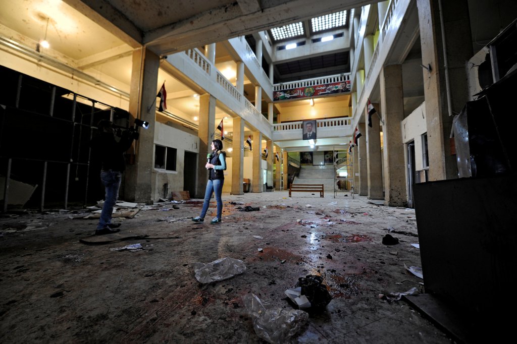 A reporter stands over blood stains after a suicide blast at the Palace of Justice in Damascus, Syria March 15, 2017. REUTERS/Omar Sanadiki

