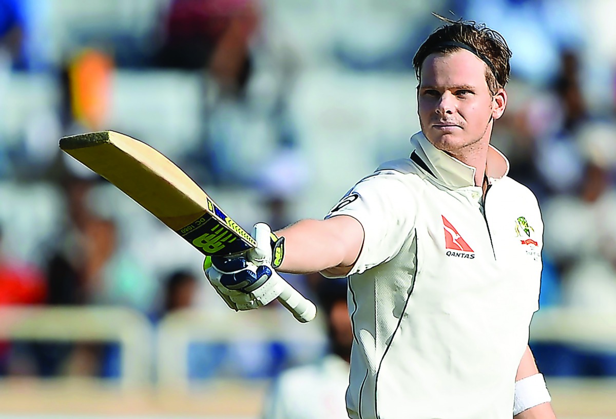 Australia's captain Steve Smith raises his bat while celebrating after scoring a century during the first day of the third Test against India at the Jharkhand State Cricket Association (JSCA) Stadium Complex in Ranchi.