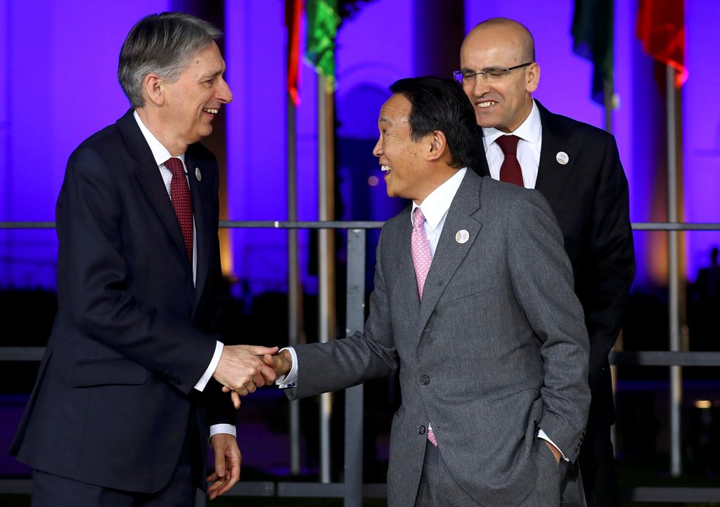 Japanese Finance Minister Taro Aso and Britain's Chancellor of the Exchequer Philip Hammond arrive for the family photo at the G20 Finance Ministers and Central Bank Governors Meeting in Baden-Baden, Germany, March 17, 2017. REUTERS/Kai Pfaffenbach
