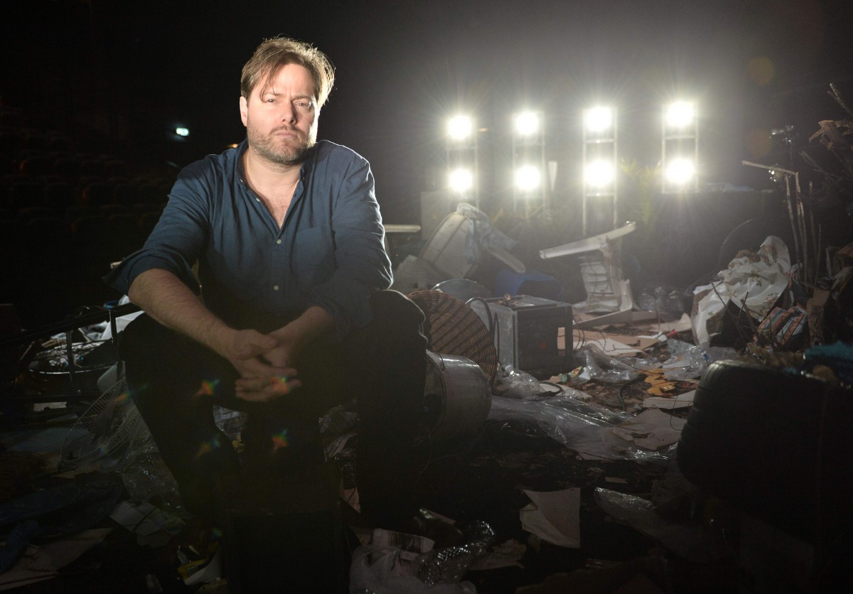 Swiss theatre director Milo Rau posing for photographs on a set created for his play 