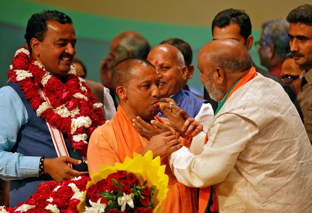 India’s ruling Bharatiya Janata Party (BJP) leader Yogi Adityanath (C) is offered sweets after he was elected as Chief Minister of India’s most populous state of Uttar Pradesh, during the party lawmakers' meeting in Lucknow, India March 18, 2017. REUTERS/