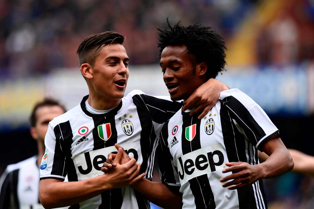 Juventus' Colombian forward Juan Cuadrado (R) celebrates with Juventus' Argentinian forward Paulo Dybala after scoring a goal during the Italian Serie A football match Sampdoria versus Juventus on March 19, 2017 at the Luigi Ferraris stadium in Genova. / 